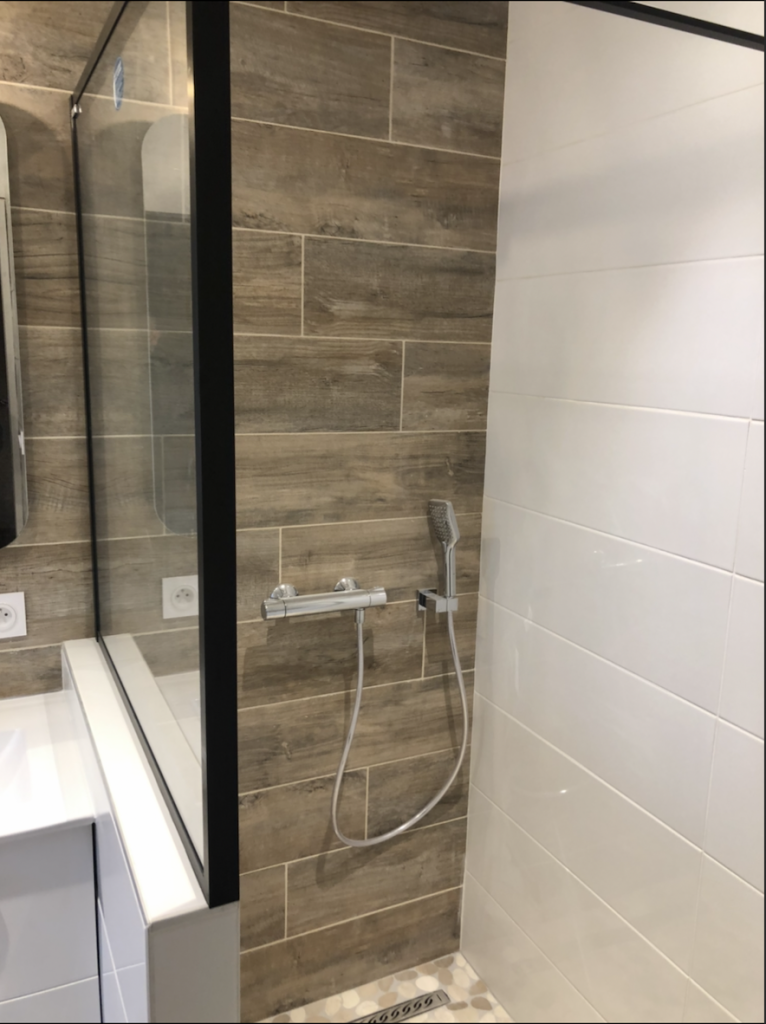 Douche fermée par une paroi vitrée à profil noir, carrelage imitation bois