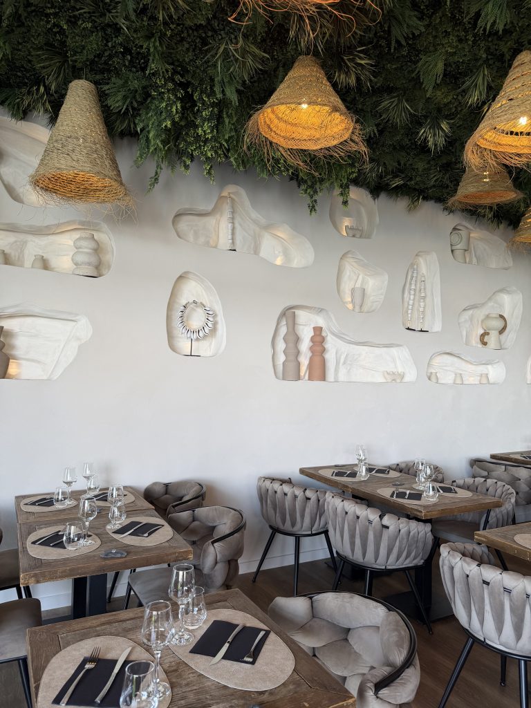Salle du restaurant D’Calé, niches sculptées dans le mur et suspensions en fibre naturelle