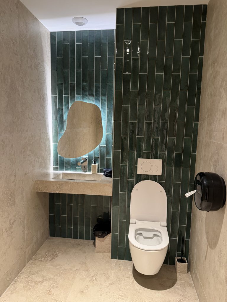 Toilettes du D’Calé, faïence verte en long format et miroir rétroéclairé